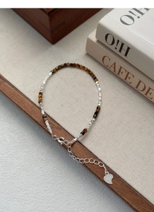 Detail of S925 sterling silver bracelet with tiger eye stones and S925 heart pendant
