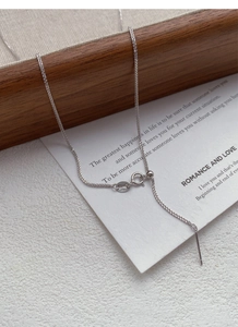 Macro detail of S925 sterling silver chain with adjustable slide bead and needle end