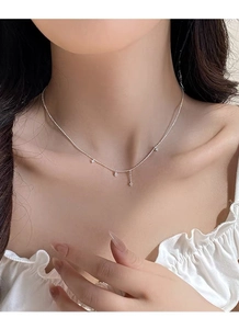 Détail du collier à perles en argent S925 avec breloques étoile et goutte sur le cou