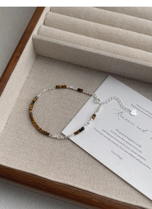 Macro detail of S925 sterling silver beads and tiger eye stones with lobster clasp