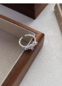 Detail of S925 silver ring featuring irregular grain texture and blue zircon inlay