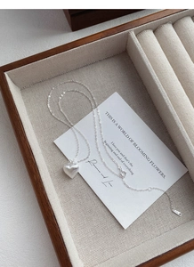 Close-up of S925 sterling silver heart necklace with brushed metal finish on display