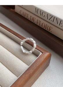 Detailed macro shot of vintage matte silver rose flower ring on soft beige velvet box