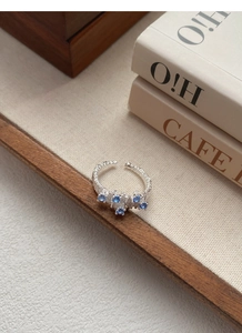 Detail view of adjustable S925 silver ring with hammered texture and five blue zircons