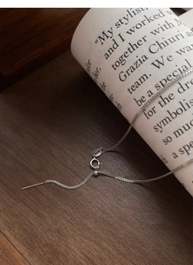 Adjustable S925 sterling silver chain with needle pin and sliding stopper on wooden desk