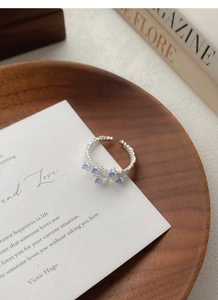 Macro shot of S925 silver ring featuring irregular texture and blue zircon square stones
