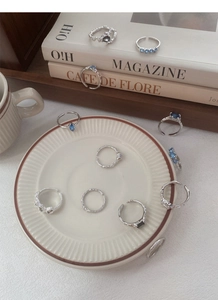 Dettaglio di anelli in argento sterling S925 con zirconi colorati su piatto in ceramica