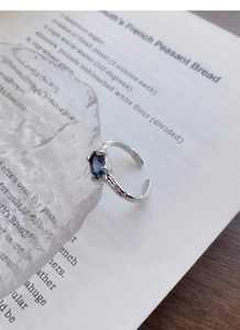 Detail of S925 sterling silver ring with blue oval zircon and irregular hand-crafted texture