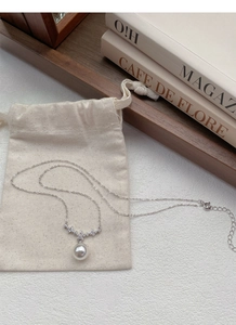 Dettaglio della collana con ciondolo di perle in argento S925 e sacchetto in lino