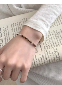 Close-up of S925 silver bracelet with natural tiger eye stones on a model's wrist
