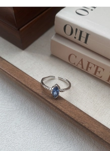 Dettaglio dell'anello in argento S925 con texture irregolare e zircone blu marquise