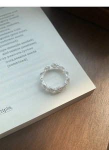 Macro detail of matte S925 sterling silver ring with 3D rose carvings on vintage book