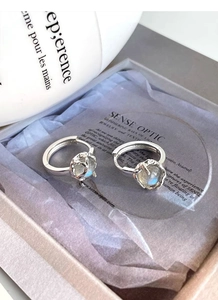 Macro view of S925 silver hoop earrings featuring blue moonstone in a luxury jewelry box