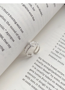 Primo piano dell'anello doppio in argento S925 con zircone posto tra le pagine