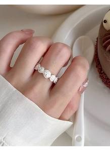Close-up of matte silver S925 sterling silver rose ring worn on a finger for detail
