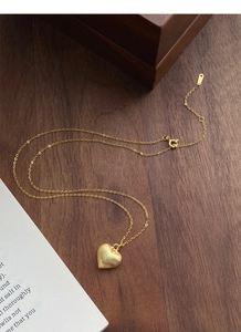 Macro detail of S925 sterling silver heart pendant with fine brushed golden texture