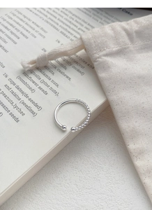 Detail of S925 sterling silver ring with minimalist beaded chain and smooth polished finish