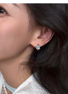 Close-up of S925 sterling silver hoop earring with moonstone on woman's ear
