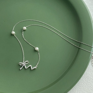 Elegant 925 sterling silver necklace featuring bow pendant with pearls and diamonds