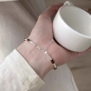 S925 sterling silver bracelet with tiger eye stones worn on wrist with cozy home vibe