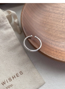 Close-up of S925 sterling silver ring showing beaded design and hallmark on wood tray