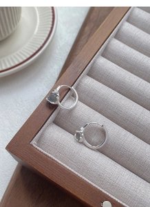 Detail of S925 silver moonstone hoop earrings inside a premium wooden jewelry box