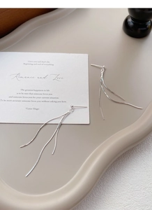 Minimalist S925 sterling silver long chain tassel earrings displayed on a beige tray
