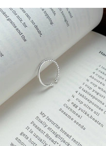Detailed view of S925 sterling silver beaded ring placed elegantly on a book page