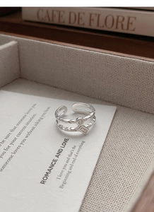 Dettaglio dell'anello a doppio strato in argento S925 con texture martellata e zirconi