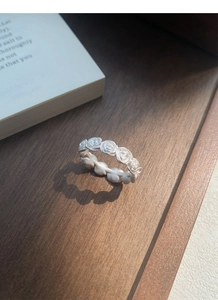 Close-up of matte S925 sterling silver rose flower ring on a vintage wooden background