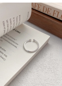 Detail shot of a minimalist S925 sterling silver ring with smooth and beaded texture