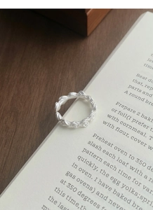 Detailed macro view of S925 sterling silver matte rose flower relief ring on book