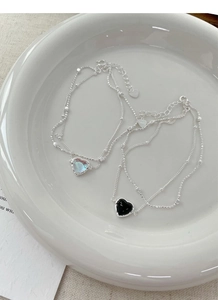 Detailed macro of S925 silver double-layer heart bracelet with moonstone and onyx