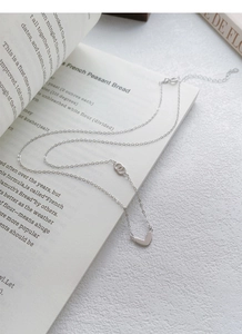 Detail of S925 silver heart necklace with interlocking rings on a lobster clasp