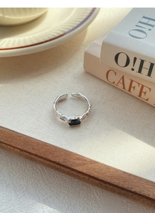 Dettaglio dell'anello in argento S925 con texture lavica irregolare e zircone nero rettangolare
