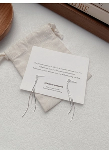 Detail of S925 sterling silver tassel drop earrings with a minimalist velvet drawstring bag