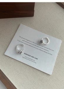 Close-up of S925 sterling silver moonstone earrings on a vintage aesthetic background