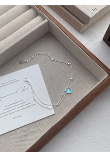 Close-up of S925 sterling silver heart bracelet with moonstone on beige velvet tray