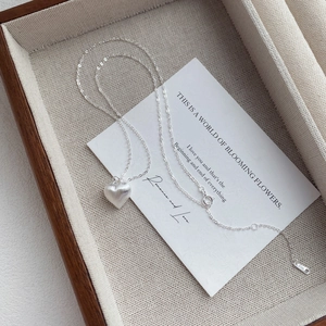 S925 sterling silver heart necklace with a brushed matte finish on a display card