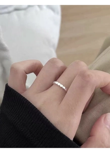 Gros plan d'une bague géométrique minimaliste en argent S925 sur le doigt d'une femme