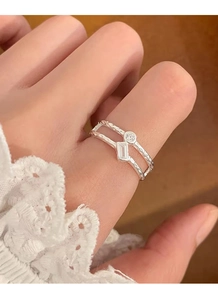 Dettaglio di un anello a doppio strato in argento S925 con zirconi su una mano femminile