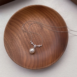 Elegante collana in argento S925 con perla e fiore di diamanti su piatto di legno