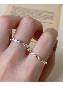 Détail de bagues en argent sterling S925 perlé et maillon sur les doigts avec livre ancien