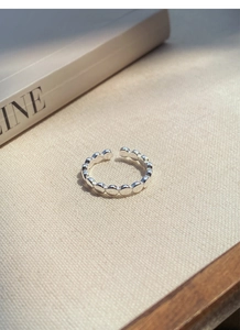 Vue détaillée d'une bague à billes en argent sterling S925 sur tissu beige texturé