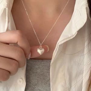 Minimalist S925 sterling silver heart necklace with brushed finish shown on a model