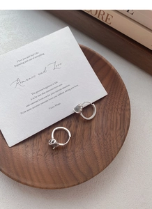 Detail of S925 sterling silver hoop earrings with moonstone on a wooden tray