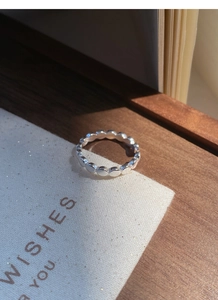Vue macro d'une bague en argent sterling S925 avec perles ovales texturées sur tissu