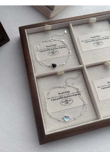 Detail of silver S925 heart bracelets with moonstone and black onyx on a jewelry display