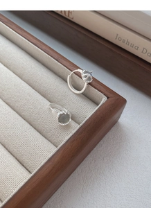 Macro detail of S925 sterling silver hoop earrings with natural moonstone in a jewelry tray