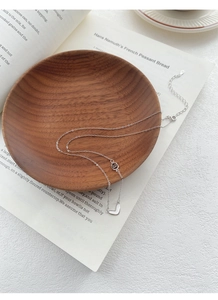 Detail of S999 sterling silver heart necklace with dual rings on a vintage book